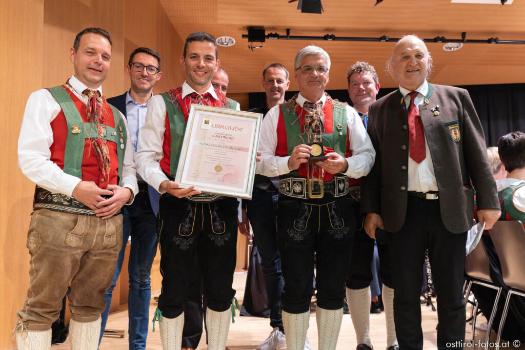 Kapellmeister Thomas Frank und Obmann Franz Webhofer bei der Übergabe der Urkunde im Kultursaal Sillian